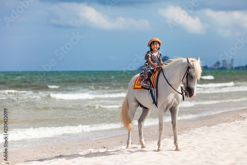 Close up portrait of kids and horse . little girl ride a horse and Tenderness and caring for White horse On the beach.