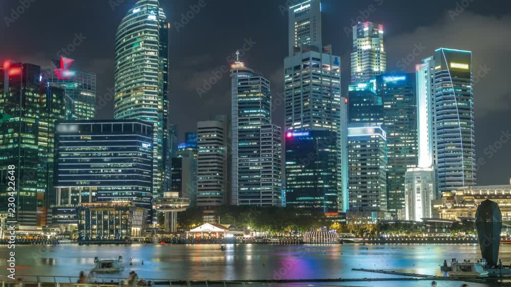 A view of Singapore business district skyscrapers in the night time with water reflections timelapse A view of Singapore business district skyscrapers in the night time with water reflections timelapse