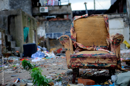 Photography Daytime close-up of an old and worn-out armchair thrown into the street and all