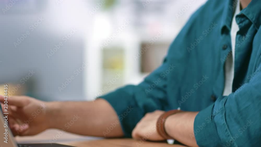 Close-up Elevating Shot of Handsome Man Typing on a Laptop and Smiling. Close-up Elevating Shot of Handsome Man Typing on a Laptop and Smiling.