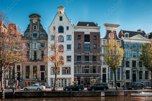 Photography Amsterdam during Autumn by the canals with boats and house, historical center of