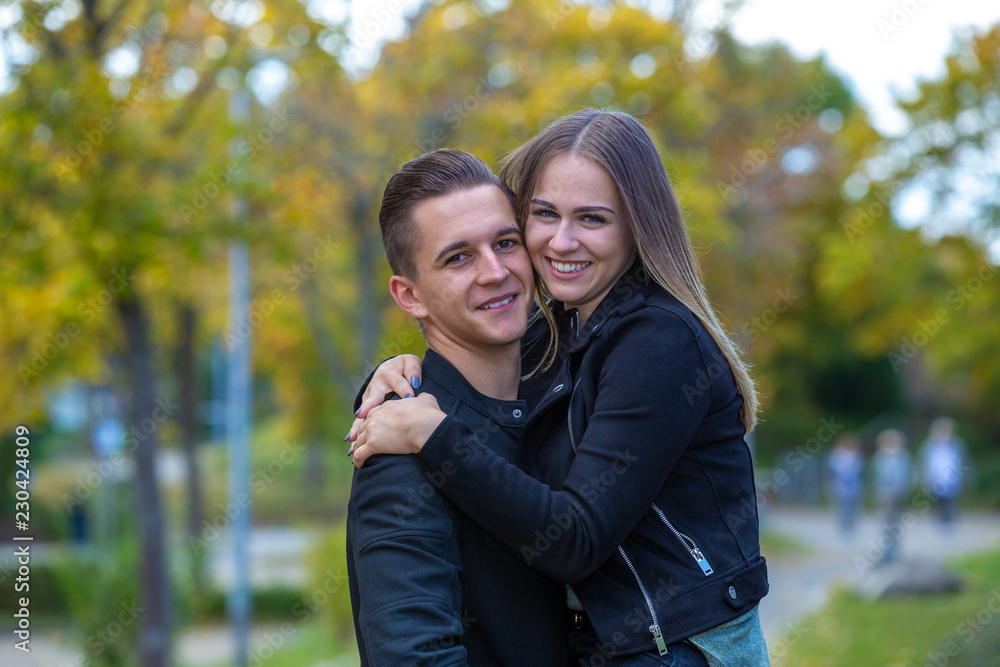 Fototapeta premium Young couple in love walking in the autumn park