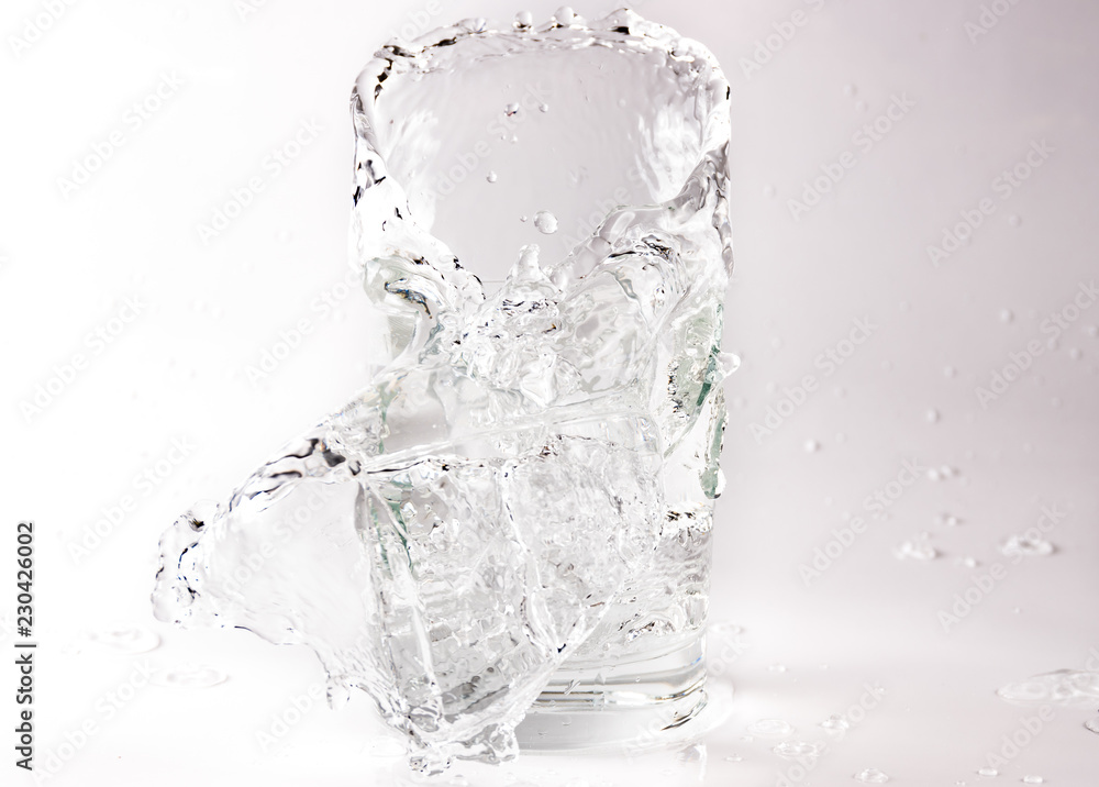 Falling and crashing glass of water. Shards of glass and splashing water Falling and crashing glass of water. Shards of glass and splashing water