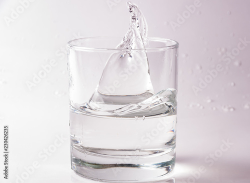 Glasses of water falling and jumping with splashes and drops 