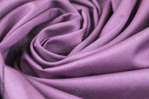 The monophonic fabric of lilac color showing a beautiful drapery a spiral.