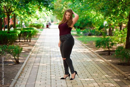 Konstfotografi Plus size fashion model in casual clothes, overweight female body in a park outdoors