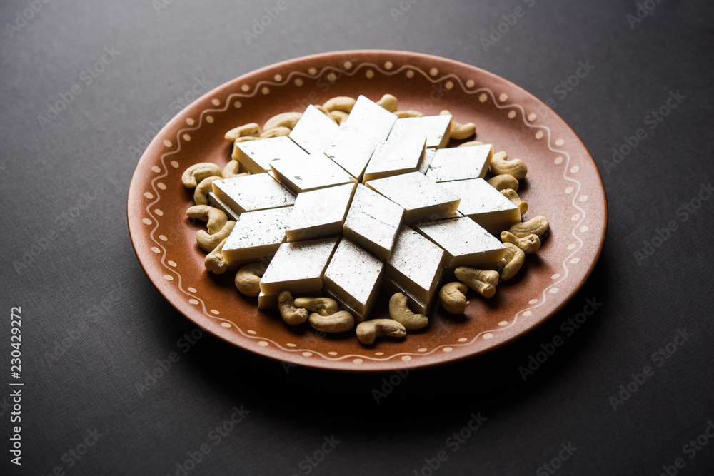 Kaju Katli is a Diamond shape Indian sweet made using cashew sugar and mava, served in a plate or bowl over moody background. selective focus Kaju Katli is a Diamond shape Indian sweet made using cashew sugar and mava, served in a plate or bowl over moody background. selective focus
