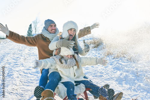 Familie rodelt durch den Schnee