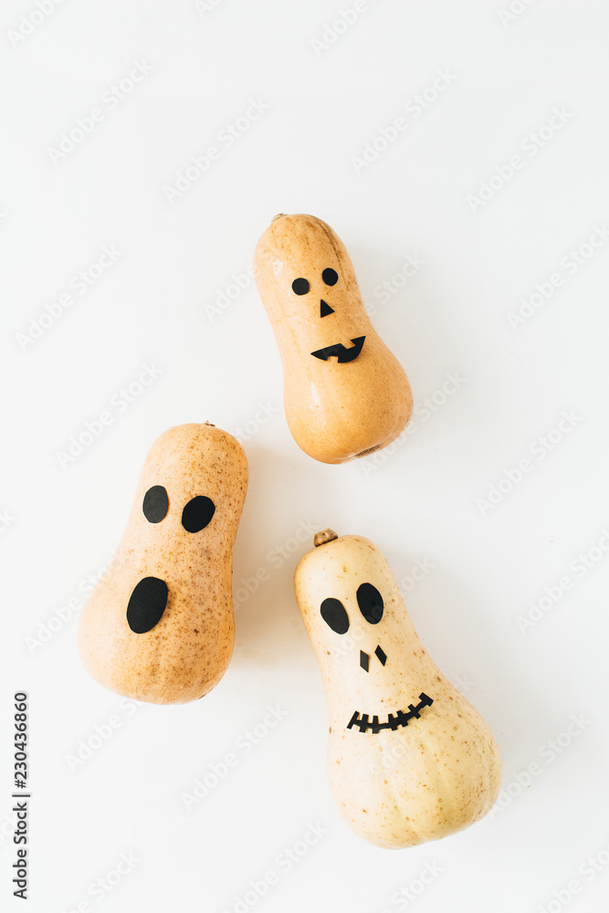 Fun scary face Halloween pumpkins on white background. Flat lay, top view background. Fun scary face Halloween pumpkins on white background. Flat lay, top view background.