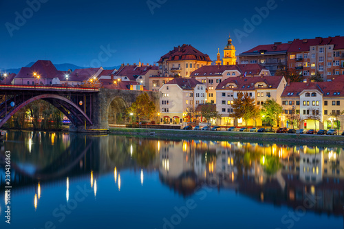 Maribor, Slovenia. Cityscape image of Maribor, Slovenia during autumn twilight blue hour with reflection of the city in Drava River. photo