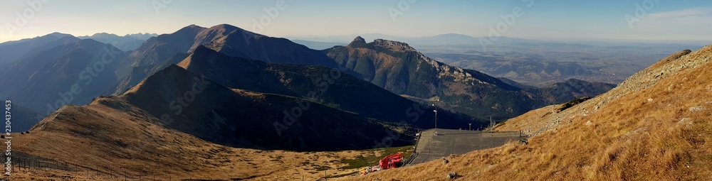Fototapeta premium Krajobraz polskich gór z Kasprowego Wierchu, na środku Giewont, a po lewej widoczny szlak idący grzbietem gór, prowadzący pod krzyż Giewontu