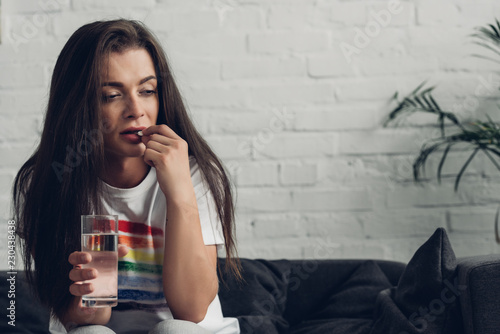 Εκτύπωση καμβά depressed young transgender man taking pill on couch