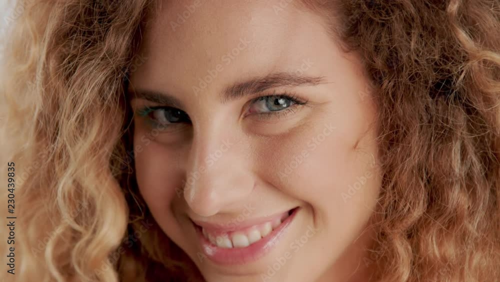 panned closeup video green eyed model with blonde curly hair watching at camera and smiling panned closeup video green eyed model with blonde curly hair watching at camera and smiling