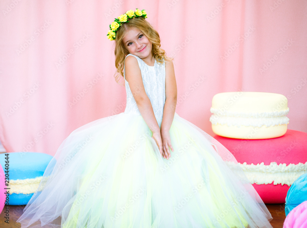 Cute little girl with blond curls in a white lush dress with giant ...