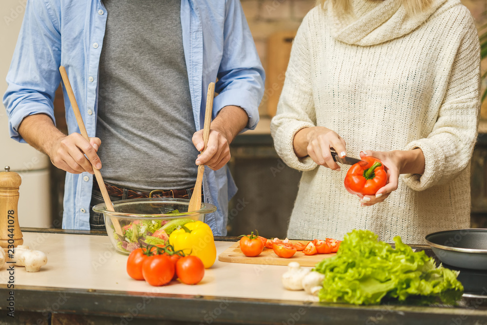 Lovely couple are talking and while cooking healthy food in kitchen at home. Close-Up. Lovely couple are talking and while cooking healthy food in kitchen at home. Close-Up.
