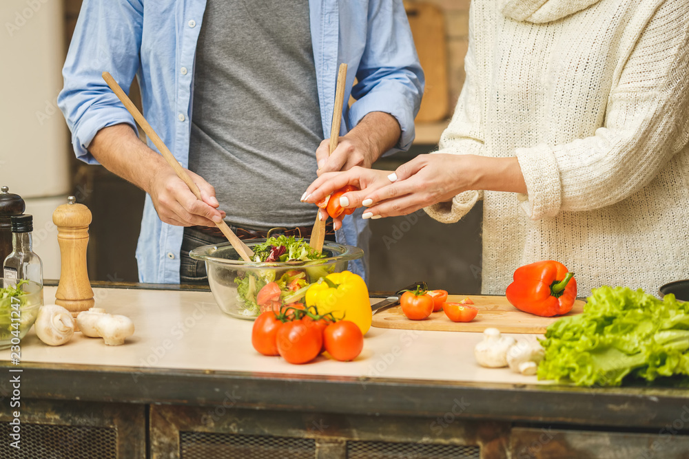 Lovely couple are talking and while cooking healthy food in kitchen at home. Close-Up. Lovely couple are talking and while cooking healthy food in kitchen at home. Close-Up.