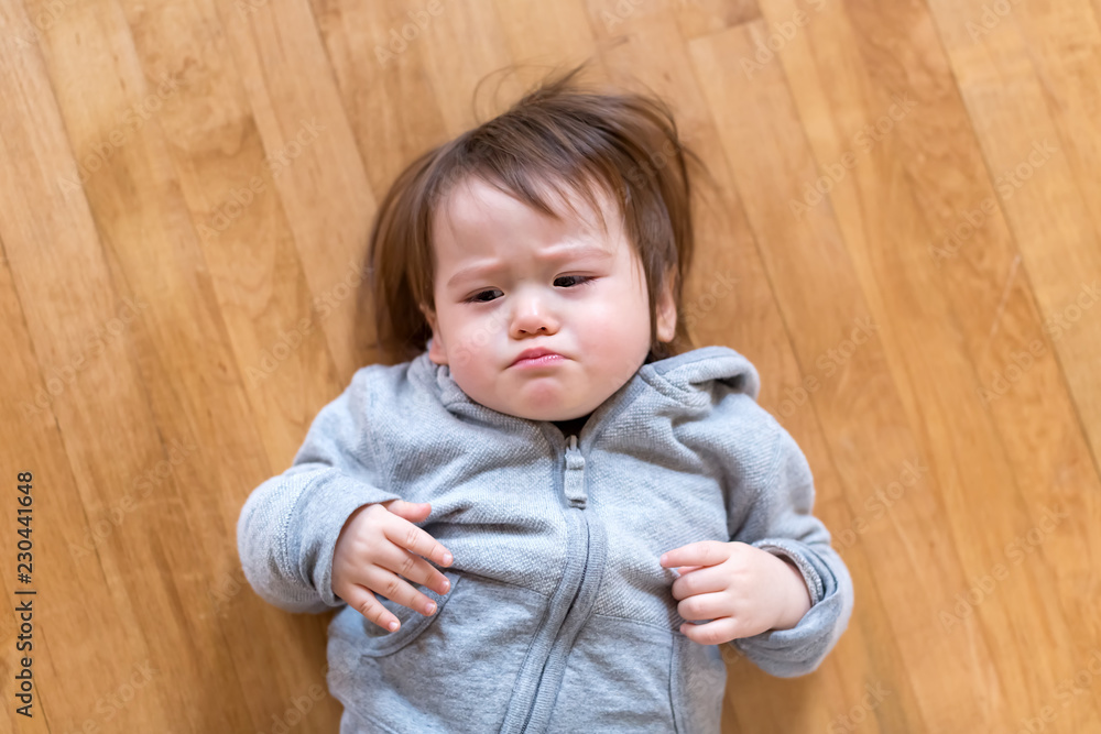 Upset toddler boy laying down in his house Upset toddler boy laying down in his house