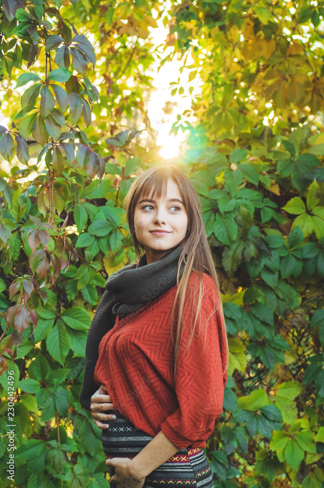 Beauty Romantic Girl Outdoors enjoying nature holding leaves in hands. Beautiful autumn model with waving glow hair. Sun light Beauty Romantic Girl Outdoors enjoying nature holding leaves in hands. Beautiful autumn model with waving glow hair. Sun light