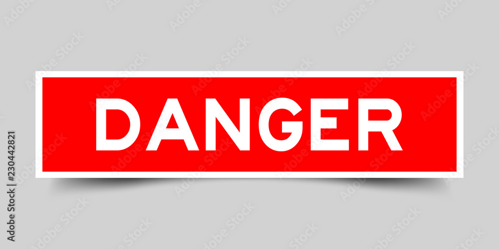 Square red sticker label in word danger on gray background Square red sticker label in word danger on gray background