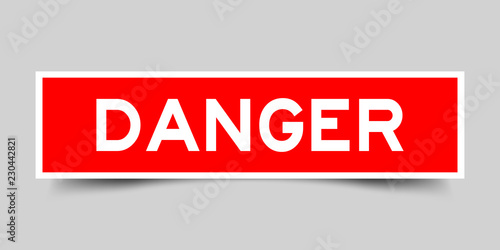 Square red sticker label in word danger on gray background