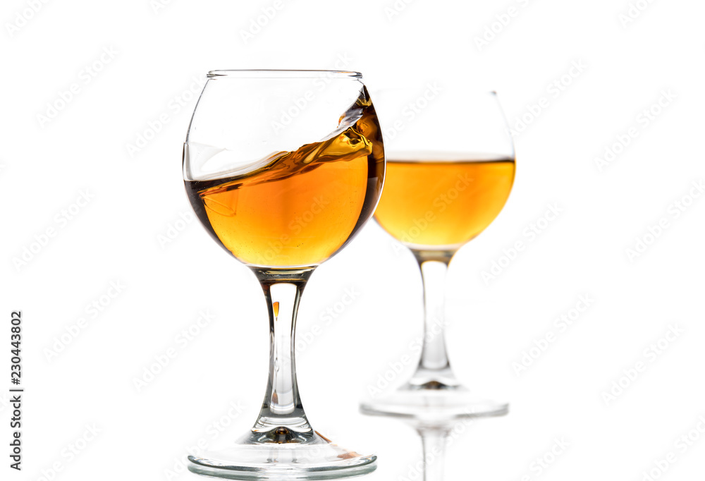 A round glass with brandy and a splash of drink inside A round glass with brandy and a splash of drink inside
