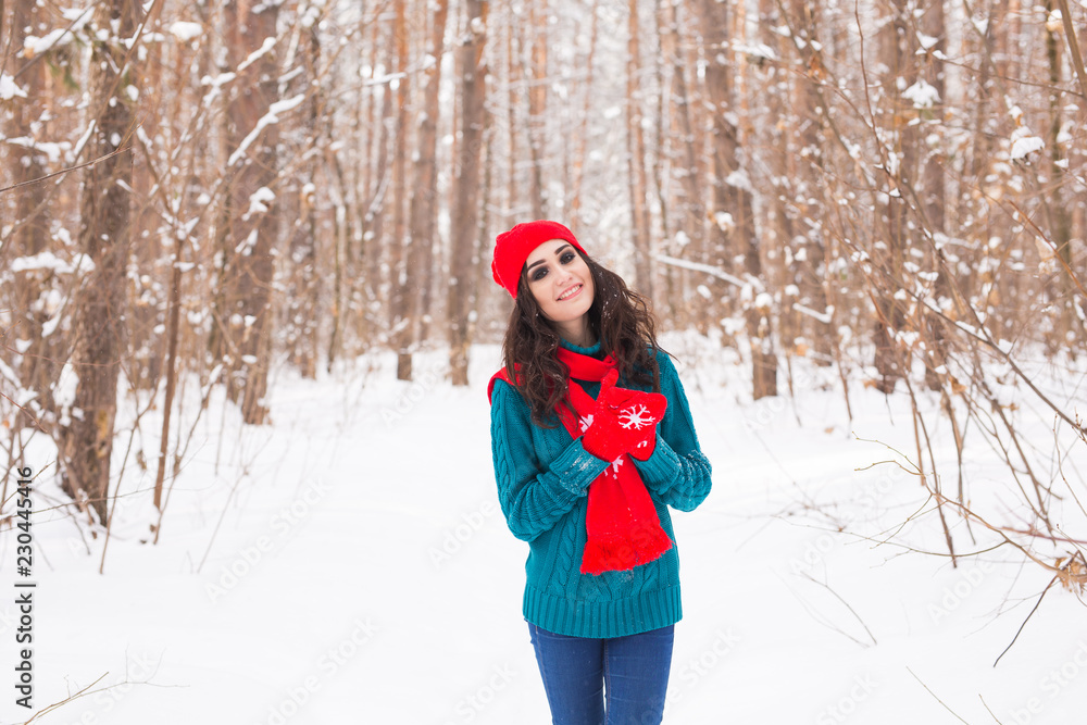 Young pretty woman walking in the winter snowy park at sunny day Young pretty woman walking in the winter snowy park at sunny day