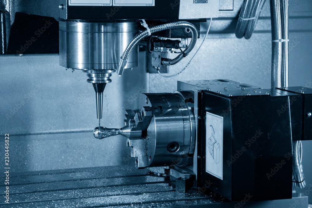 The 4-axis CNC milling machine or machining center attach the rotation axis cutting the sample part with the solid ball endmill tool in the light blue scene.The Hi-Technology manufacturing process. The 4-axis CNC milling machine or machining center attach the rotation axis cutting the sample part with the solid ball endmill tool in the light blue scene.The Hi-Technology manufacturing process.