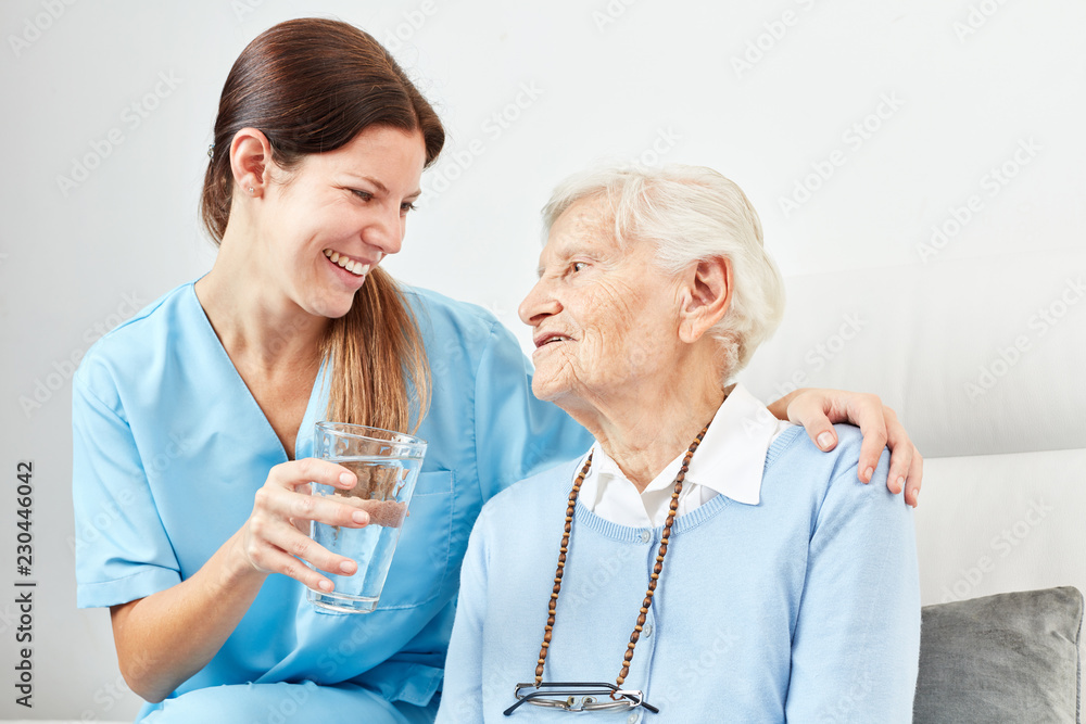 Pflegedienst Frau gibt Seniorin ein Medikament Pflegedienst Frau gibt Seniorin ein Medikament