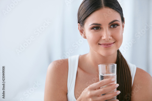 Happy Woman Drinking Water. Beautiful Female With Glass Of Water