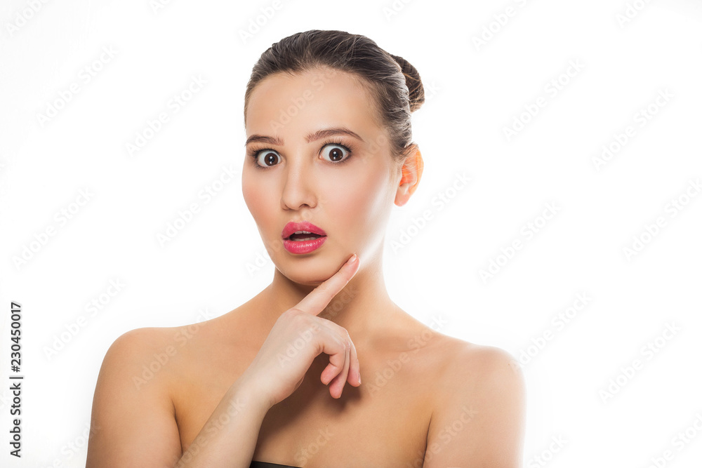 young beautiful brunette girl with natural makeup, clean skin exposed bare shoulders looking at the camera with mouth open hand on his chin finger emotions gestures Spa body care