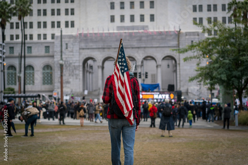 A young man carries an American flag to a protest