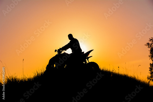 Silhouette of quad bike driver on the mountain
