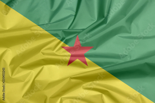 Fabric flag of French Guiana. Crease of French Guiana flag background, The green and yellow with red star.