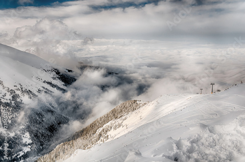 Winter Alpine snowpeak background with ountainous terrain and snow covered trees texture. Bansko, Bulgaria photo