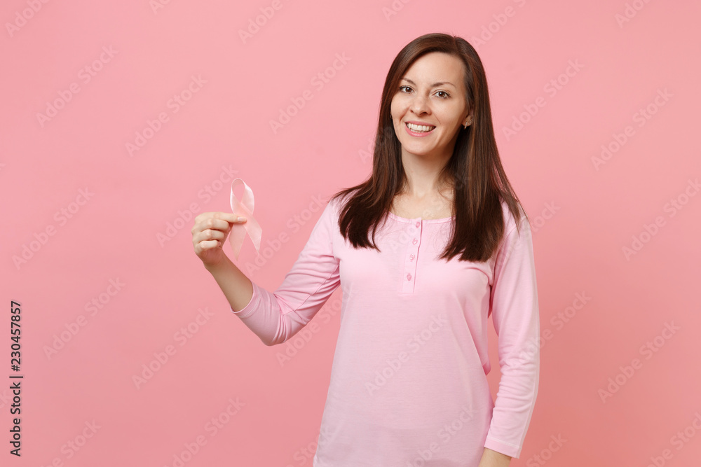 Woman in rose clothes hold in hand pink silk ribbon isolated on pastel wall background, studio portrait. Medical healthcare gynecological oncology, Breast Cancer Awareness concept. Mock up copy space. Woman in rose clothes hold in hand pink silk ribbon isolated on pastel wall background, studio portrait. Medical healthcare gynecological oncology, Breast Cancer Awareness concept. Mock up copy space.