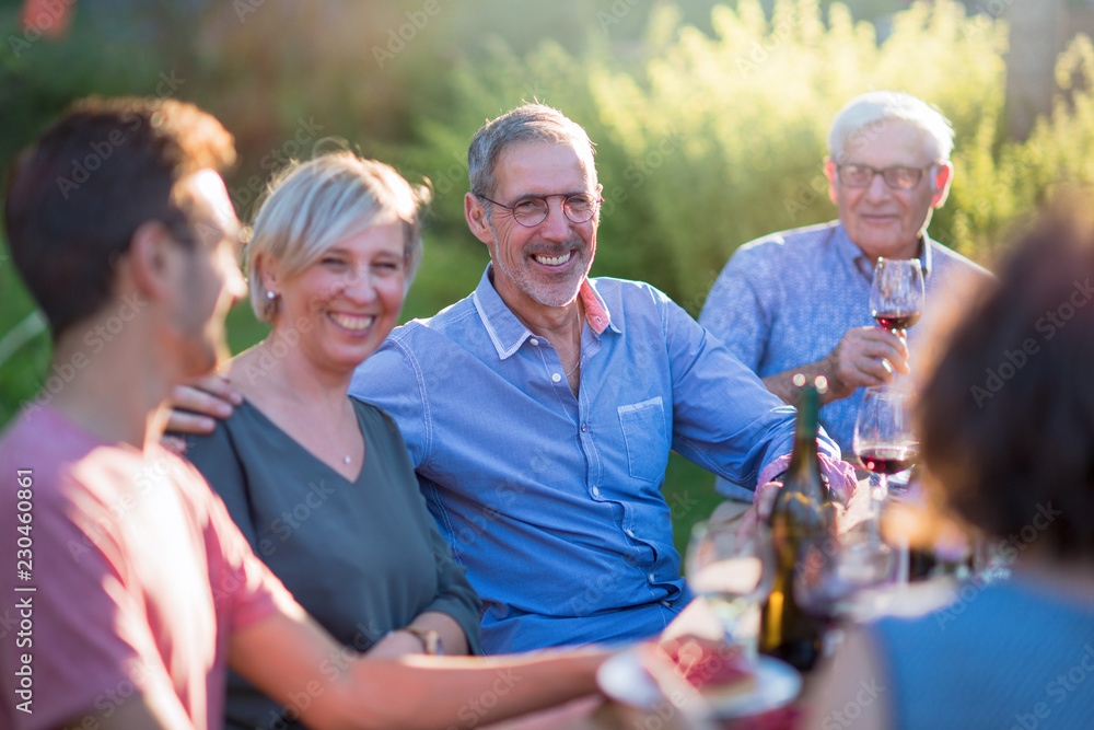 Fototapeta premium Family picnic. Focus on a handsome man looking at camera