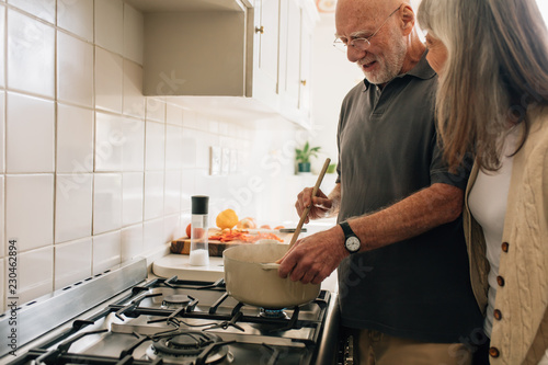 Fotografie Senior couple cooking food together at home
