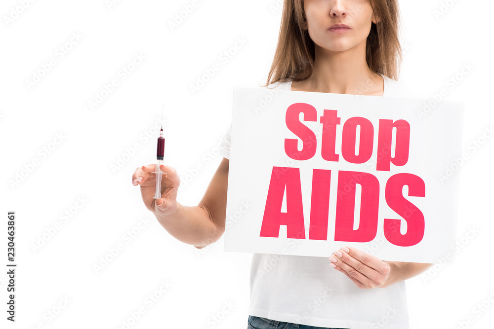 cropped image of woman holding card with stop aids text and syringe isolated on white, world aids day concept cropped image of woman holding card with stop aids text and syringe isolated on white, world aids day concept