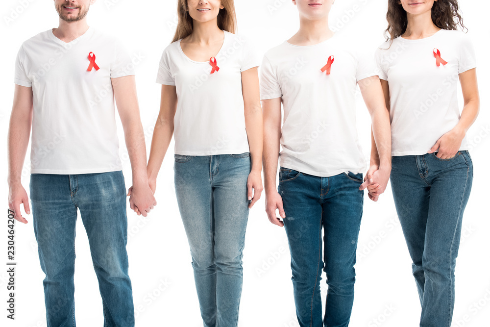 Obraz premium cropped image of men on women with red ribbons holding hands isolated on white, world aids day concept