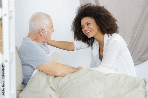 senior patient receiving help from female nurse