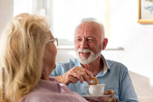 Old man and woman drinking coffee at home