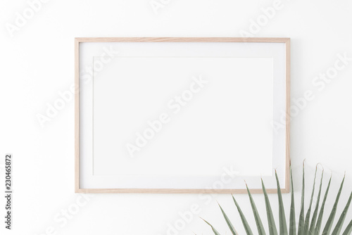 Landscape large 50x70, 20x28, a3,a4, Wooden frame mockup with passe-partout on white wall and palm leaf. Poster mockup. Clean, modern, minimal frame. Empty fra.me Indoor interior, show text or product photo