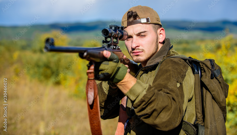 Man hunter aiming rifle nature background. Hunting skills and weapon equipment. Guy hunting nature environment. Hunting weapon gun or rifle. Hunting target. Looking at target through sniper scope