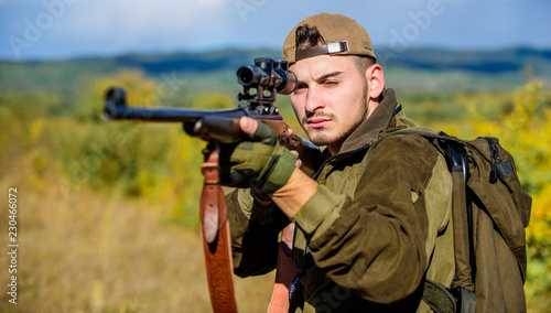 Man hunter aiming rifle nature background. Hunting skills and weapon equipment. Guy hunting nature environment. Hunting weapon gun or rifle. Hunting target. Looking at target through sniper scope