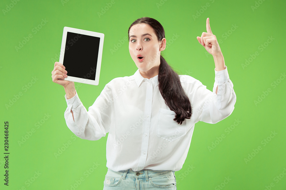 Portrait of a confident casual girl showing blank screen of laptop isolated over green background. Portrait of a confident casual girl showing blank screen of laptop isolated over green background.