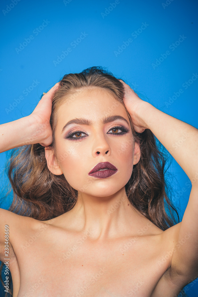Naklejka premium Fashion portrait of woman. Beauty salon and hairdresser. woman with fashion makeup and long curly hair. Makeup cosmetics and skincare. fashion girl with glamour makeup. Facial care. Confident beauty