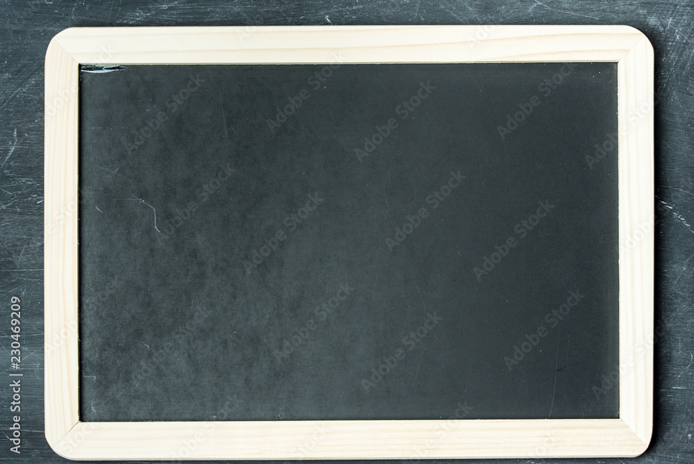 Empty black chalkboard on a black, rustic wooden wall