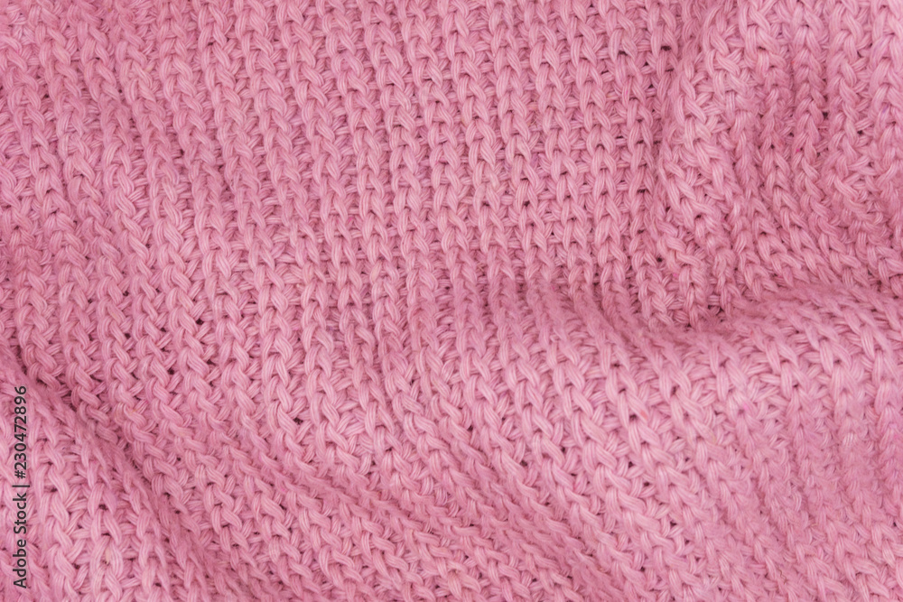 Texture of a pink knitted sweater closeup, red knitted wool Texture of a pink knitted sweater closeup, red knitted wool
