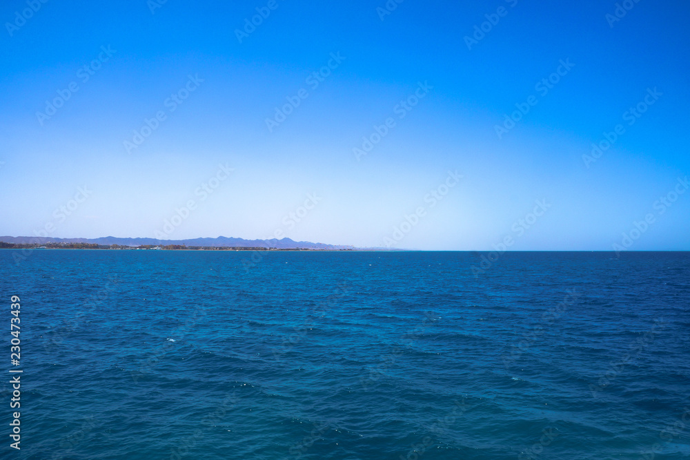 Obraz premium Beautiful blue sea surface with the sky. Oceanic deserted, lonely theme for background. Stock photo for tourist design