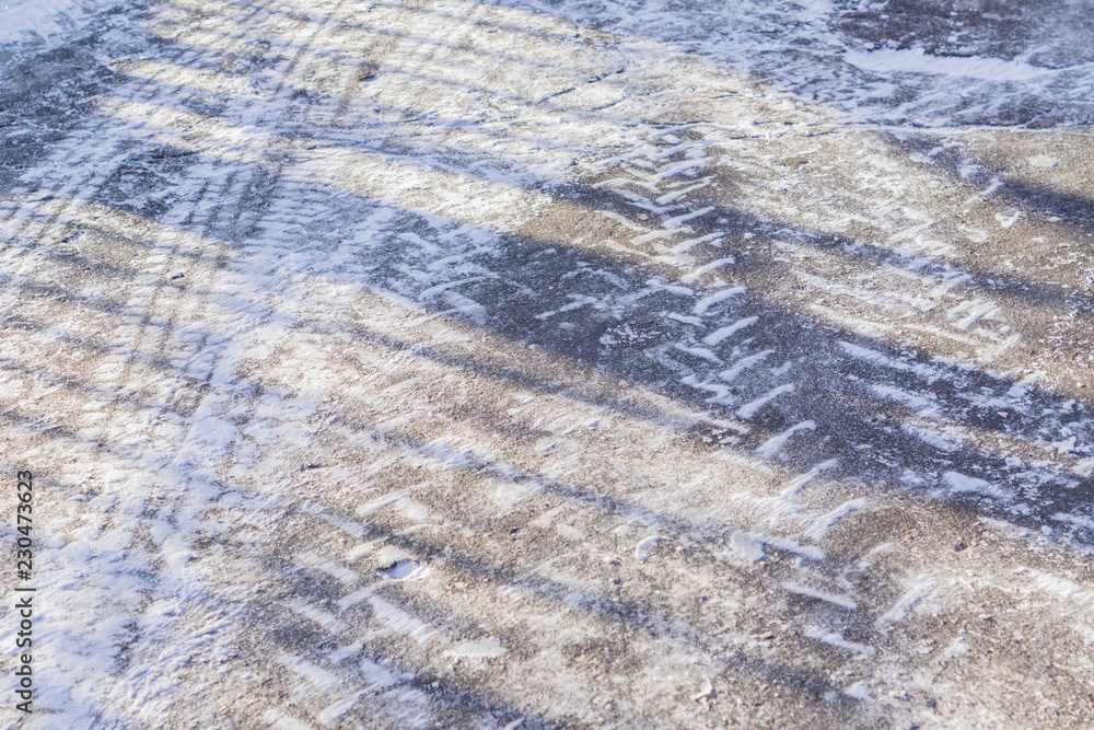 Wheel tracks on the winter road covered with snow in a sunny day Wheel tracks on the winter road covered with snow in a sunny day